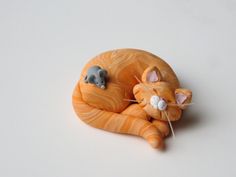 an orange cat figurine laying on its side with it's eyes closed