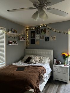 a bed room with a neatly made bed and a ceiling fan