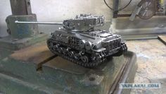 a toy tank sitting on top of a wooden table next to a machine tool box