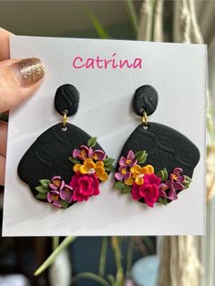 a person holding up a card with flowers on it and the caption catrina