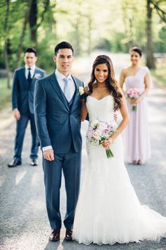 a bride and groom posing for a photo with their bridal party in the background