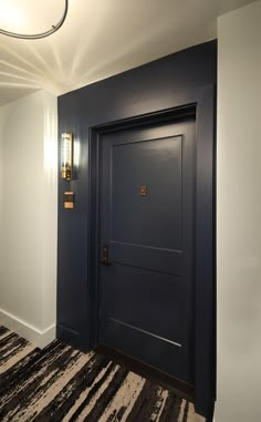 an empty room with a blue door and striped carpet