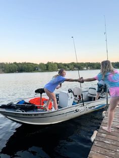 two girls are standing on a boat with fishing rods in their hands while another girl holds onto the pole