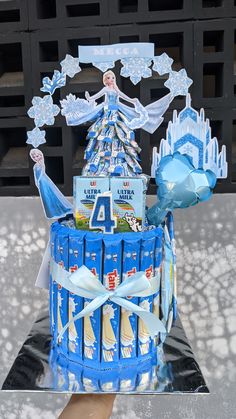 a cake made to look like an ice queen with blue frosting and decorations on top