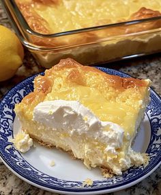 a slice of lemon pie on a blue and white plate next to a baking pan