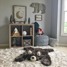 a stuffed animal laying on top of a white rug in a bedroom next to a window