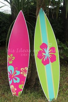 two surfboards sitting next to each other in the grass