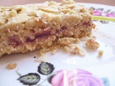 a close up of a piece of food on a plate with leaves and flowers around it