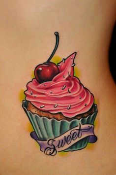 a woman with a tattoo on her back has a cupcake and cherries on it