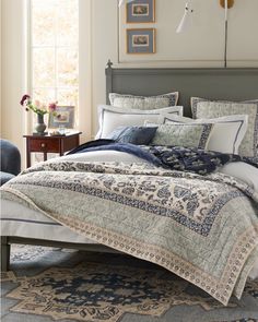 a bed with blue and white comforters in a bedroom