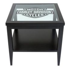 a table with a glass top and harley davidson logo on the bottom, sitting against a white background