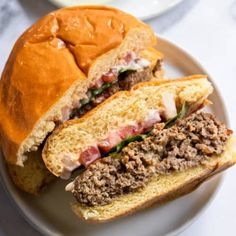 a sandwich cut in half sitting on top of a white plate