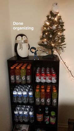 a christmas tree is next to a shelf filled with drinks