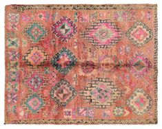 an old rug with many different colors and patterns on it, including pinks, blue,