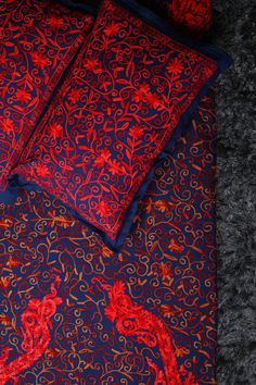 a red and blue bed spread with two pillows