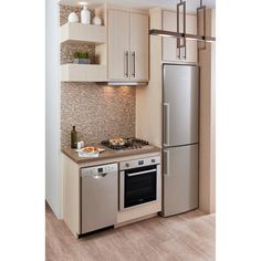 a modern kitchen with stainless steel appliances and wood flooring is pictured in this image