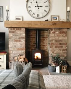 a living room with a fireplace and a large clock on the wall