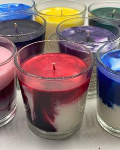 several different colored candles sitting next to each other