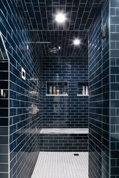 a blue tiled bathroom with white tile and black walls, along with a bathtub in the center