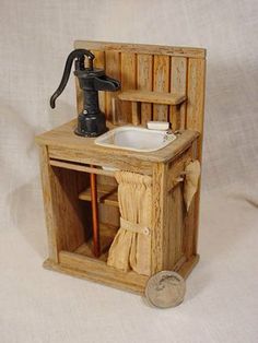 a miniature wooden sink and cabinet with a faucet