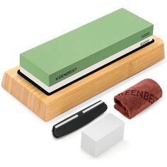 a pen, eraser and sharpener sitting on top of a wooden block next to each other