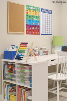 a white desk with lots of books and toys on it in a child's playroom