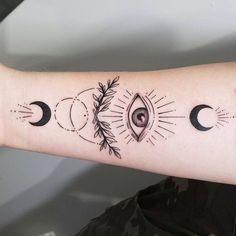 a woman's arm with three phases of the moon and an eye on it