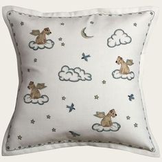 a white pillow with an angel and stars pattern on the front, sitting on top of a cloud