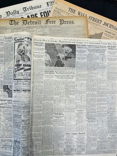 an old newspaper is laying open on top of other newspapers that have been stacked together