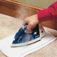 a person using a steam iron on top of a white towel