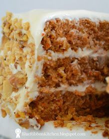 a piece of carrot cake with white frosting and walnuts on the top slice