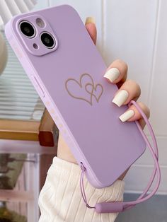 a woman holding a purple phone case with two hearts on it