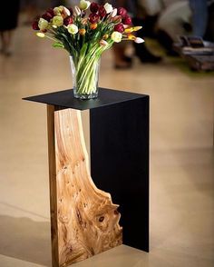 a vase filled with flowers sitting on top of a wooden stand