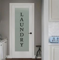 a door with the word laundry on it in front of a kitchen counter and sink