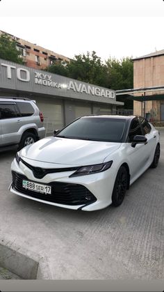 two white cars parked in front of a building