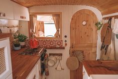 a small kitchen with wooden counters and white appliances, including a stove top oven in the corner