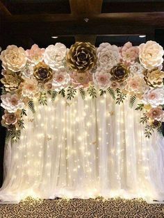 the backdrop is decorated with flowers and lights for a wedding or special event in shades of gold