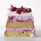 a slice of cake with raspberries and cream frosting on top is shown