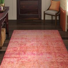 a red rug in a living room next to a chair