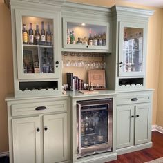 a home bar with built - in wine glasses and liquor bottles on the top shelf