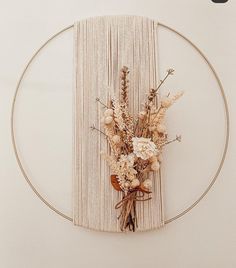 an arrangement of flowers is placed in the middle of a circular frame on a wall