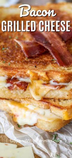 bacon grilled cheese sandwich is stacked on top of some wax paper and sits on a cutting board