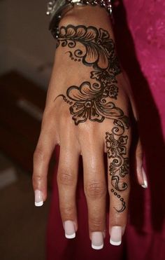 a woman's hand with henna tattoos on it