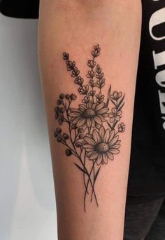 a black and white photo of a flower tattoo on the right arm with flowers in it