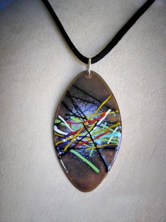 a necklace with an abstract painting on it