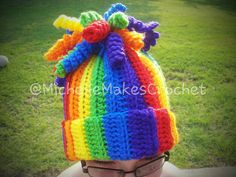 a multicolored knitted beanie hat on top of a child's head