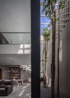 an open living room and dining area in a modern house with concrete walls, flooring and glass windows