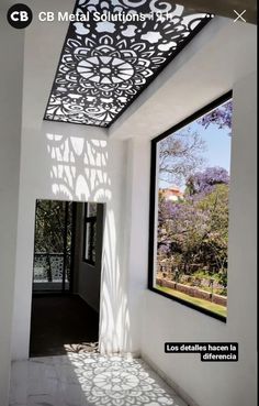 an open window in a white room with shadows on the wall and ceiling coverings