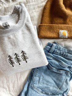 The cozy accessory your closet has been missing 🌲 This is a made to order item. Please allow 1-2 weeks before item is shipped.  Embroidered crewneck sweatshirt. Color: ash gray. 50% preshrunk cotton, 50 % polyester. Design is approximately 4 inches wide. Womens Winter Sweater, Minimalist Embroidery Ideas, Sweatshirts With Embroidery, Pnw Clothing Style, Granola Teacher Aesthetic, Cricut Crewneck, Fall Crewneck Sweatshirt Embroidery, Winter Crew Neck Top With Embroidered Logo, Casual Embroidered Winter Sweater