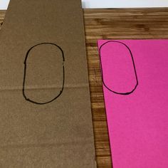 two pieces of brown paper sitting on top of a wooden table